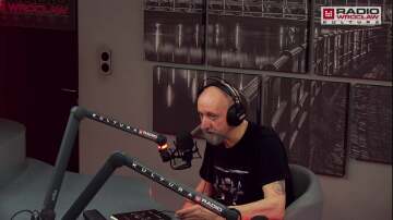 Mężczyzna ze słuchawkami na uszach w studiu nagraniowym mówi do mikrofonu